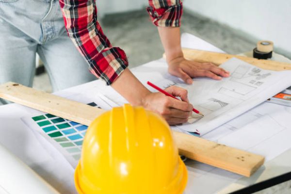 close up hand of woman engineer writing on the blueprint.